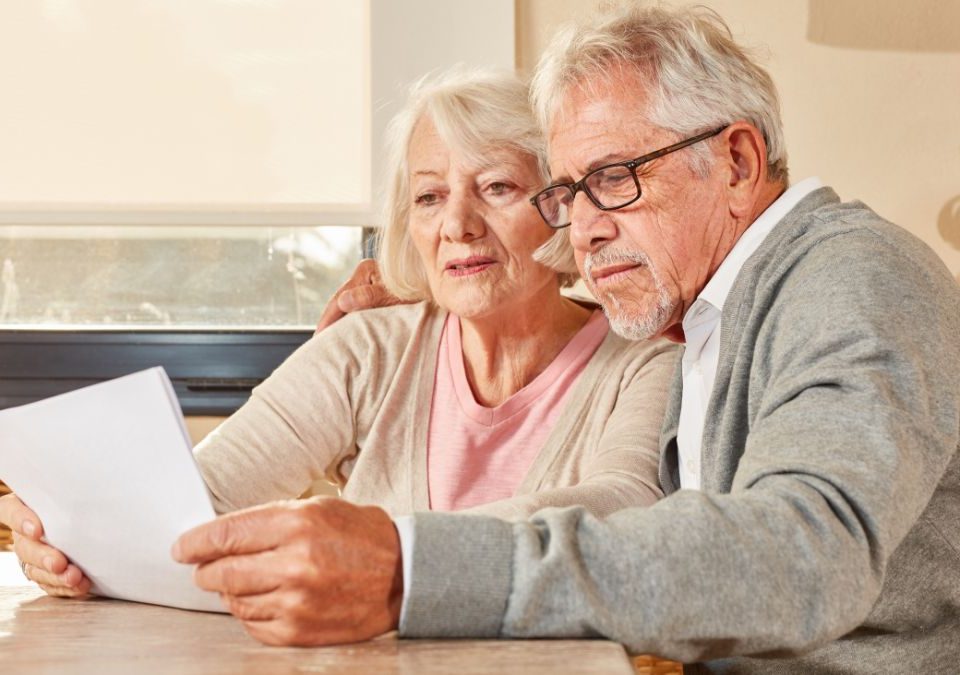 Couple de seniors qui lisent un contrat