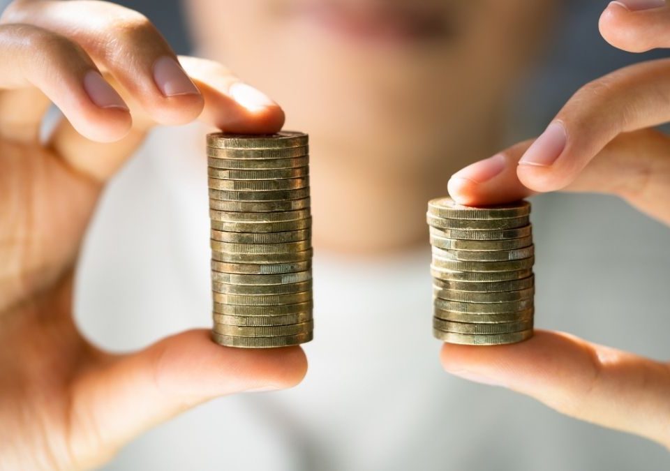 Un particulier compare deux piles de pièces d'argent pour voir laquelle est la meilleure