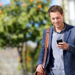 travailleur indépendant qui se renseigne sur les mutuelle santé freelance via son téléphone portable