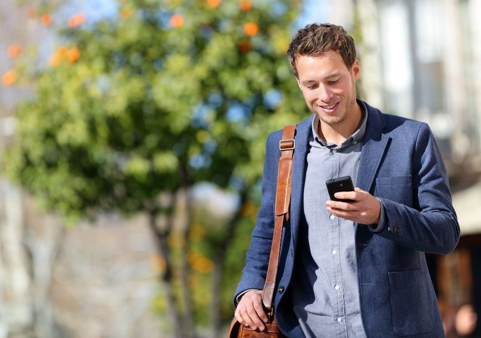 travailleur indépendant qui se renseigne sur les mutuelle santé freelance via son téléphone portable